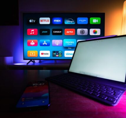 Telewizor z menu aplikacji streamingowych oraz tablet i smartfon na stole